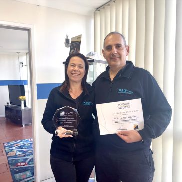 Einat and Shlomi Kuba holding the 2026 Logan Business Distinction Awards trophy and Certificate of Distinction for the Automotive and Transport Small category at K&G Automotive in Underwood